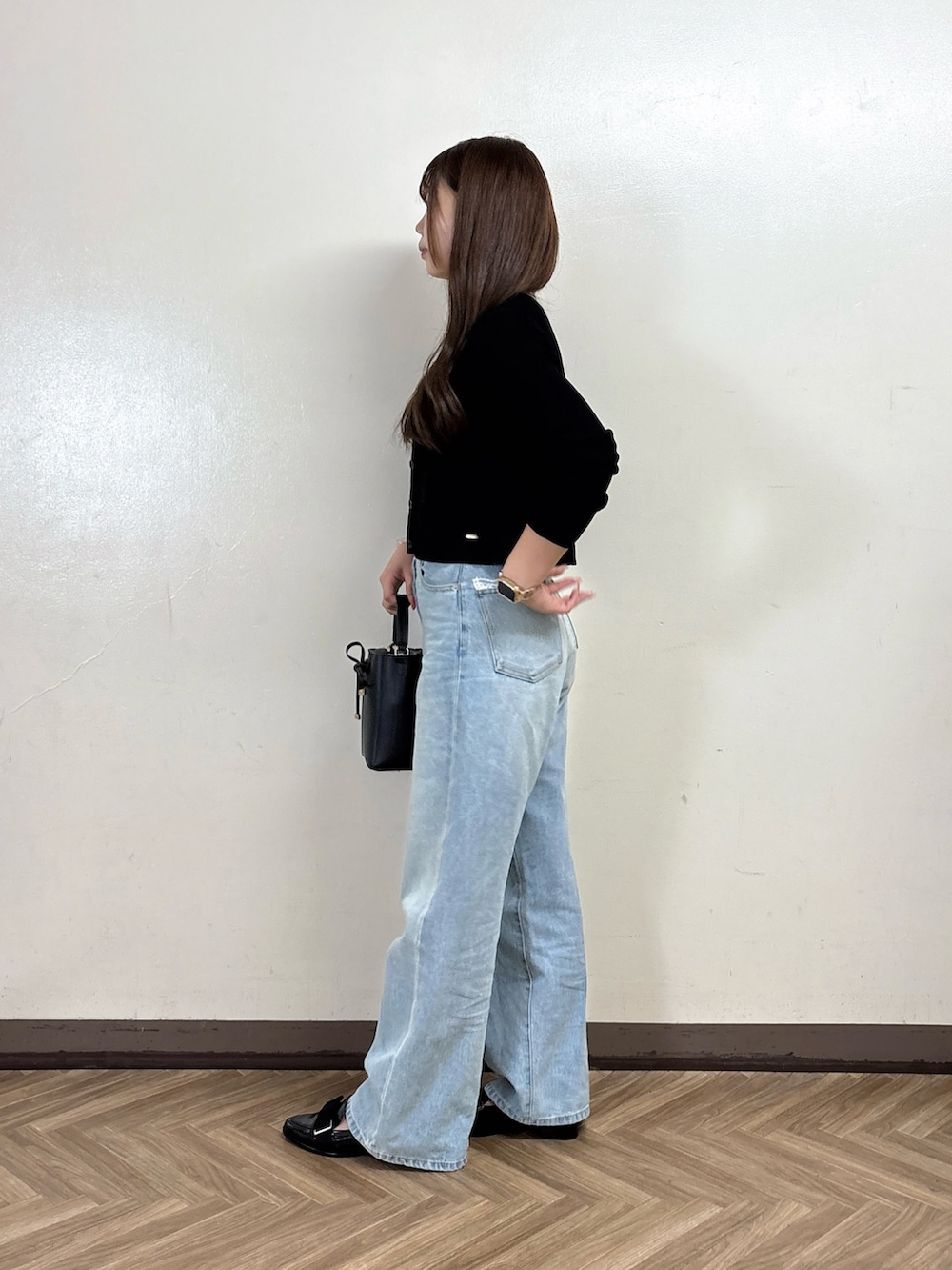 ブルー系のデニムパンツ、グレー系のTシャツ/カットソー、ブラック系のカーディガン/ボレロを着用したレディースの秋コーディネートの3枚目の写真