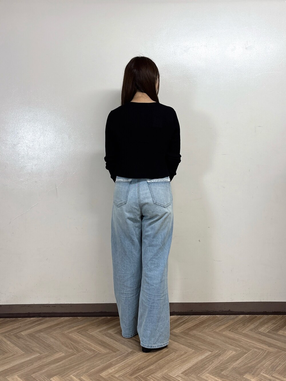 ブルー系のデニムパンツ、グレー系のTシャツ/カットソー、ブラック系のカーディガン/ボレロを着用したレディースの秋コーディネートの4枚目の写真