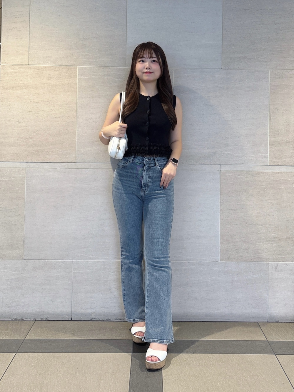 ブルー系のデニムパンツ、ブラック系のニット/セーターを着用したレディースの夏コーディネートの2枚目の写真