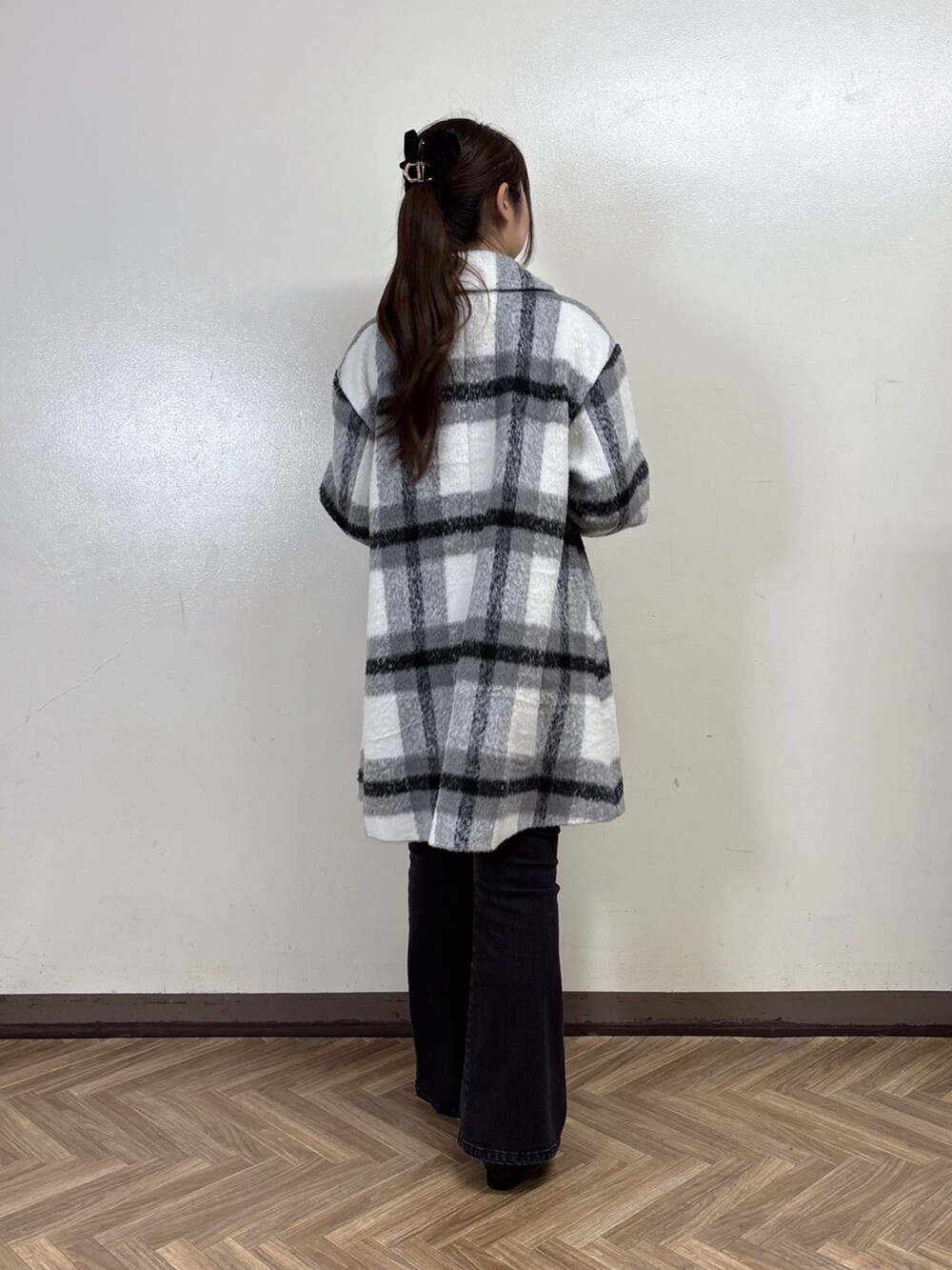 ブラック系のステンカラーコート、ブラック系のデニムパンツ、ホワイト系のカーディガン/ボレロを着用したレディースの秋コーディネートの4枚目の写真