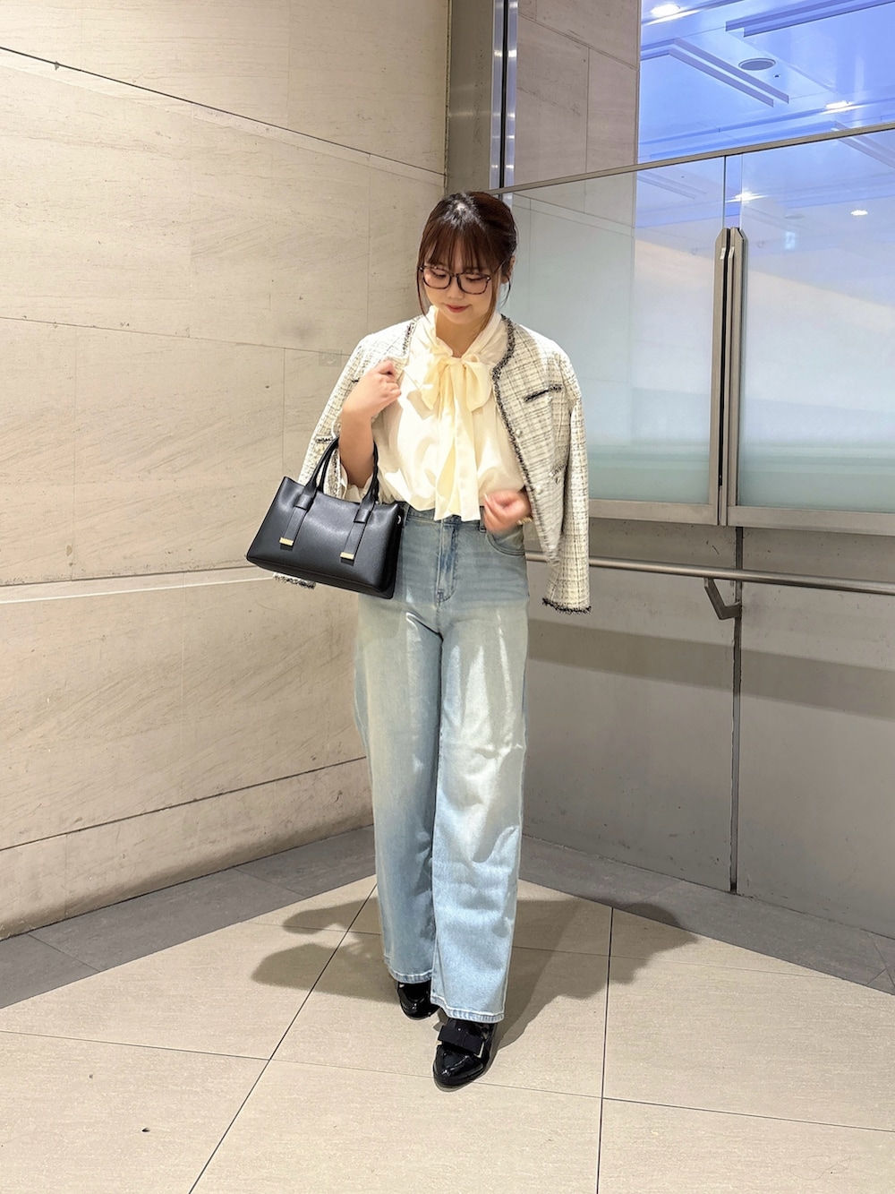 ホワイト系のシャツ/ブラウス、ホワイト系のノーカラージャケット、ブルー系のデニムパンツを着用したレディースの秋コーディネートの4枚目の写真