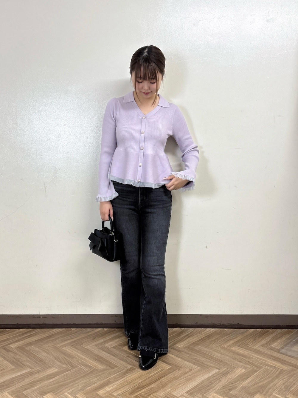 ブラック系のデニムパンツ、パープル系のニット/セーターを着用したレディースの秋コーディネートの2枚目の写真