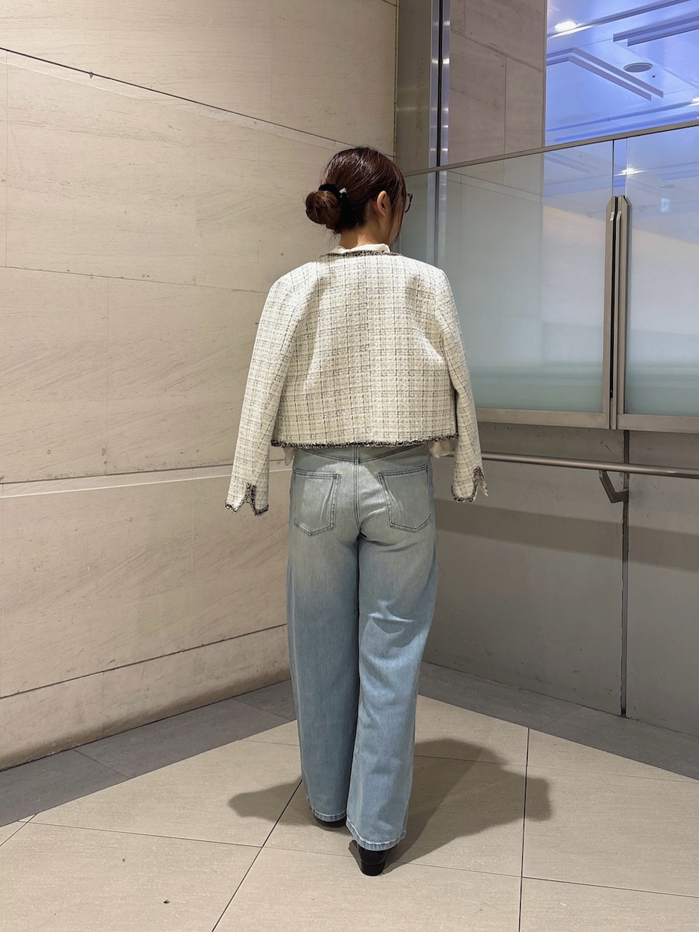 ホワイト系のシャツ/ブラウス、ホワイト系のノーカラージャケット、ブルー系のデニムパンツを着用したレディースの秋コーディネートの3枚目の写真