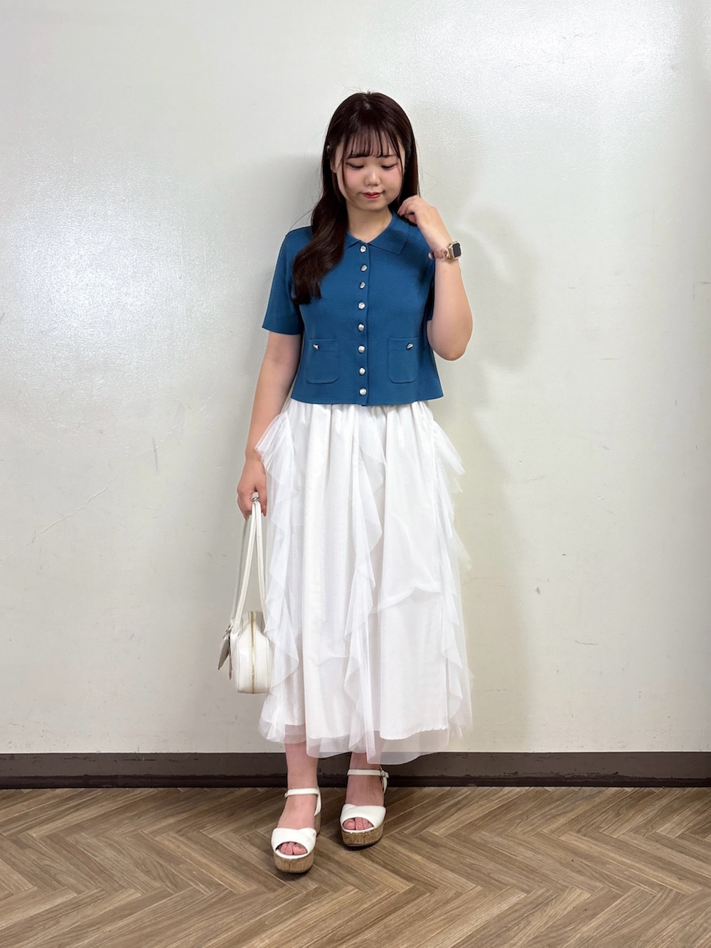 ホワイト系のスカート、グリーン系のカーディガン/ボレロを着用したレディースの夏コーディネートの3枚目の写真
