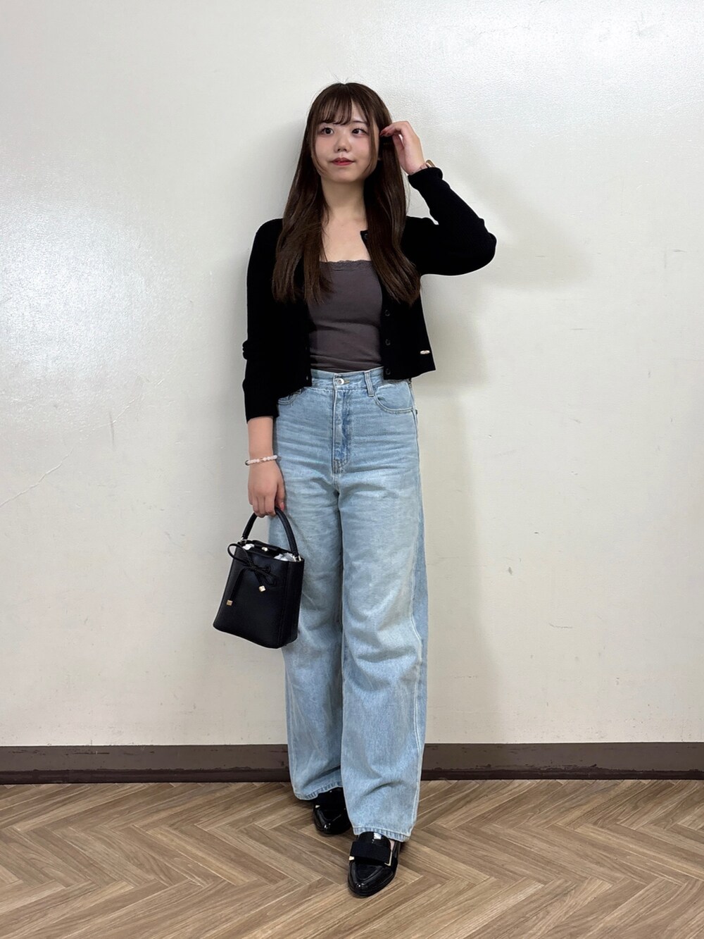ブルー系のデニムパンツ、グレー系のTシャツ/カットソー、ブラック系のカーディガン/ボレロを着用したレディースの秋コーディネートの2枚目の写真