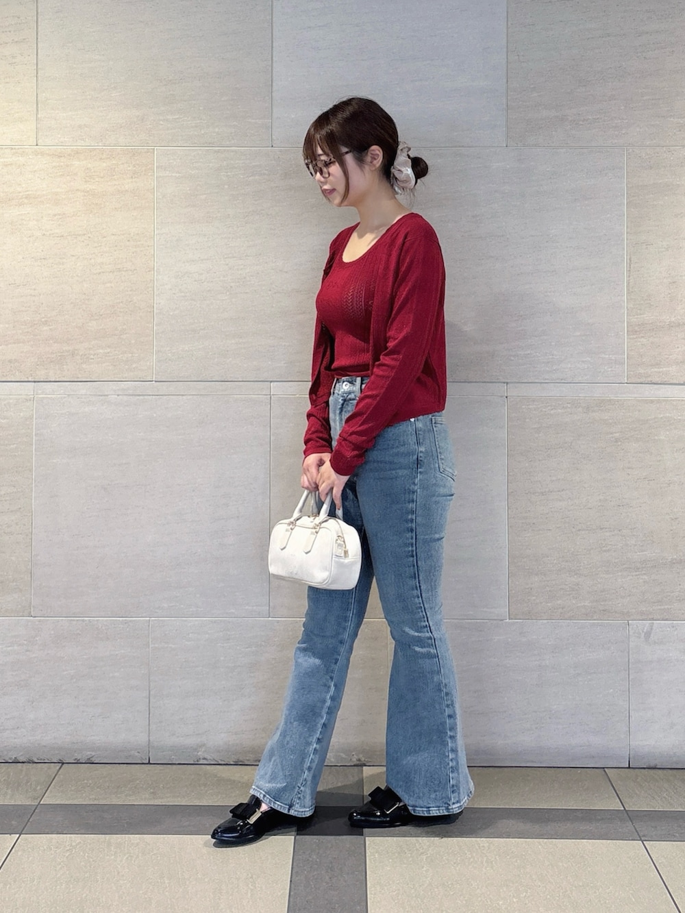 レッド系のアンサンブル、ブルー系のデニムパンツを着用したレディースの秋コーディネートの3枚目の写真