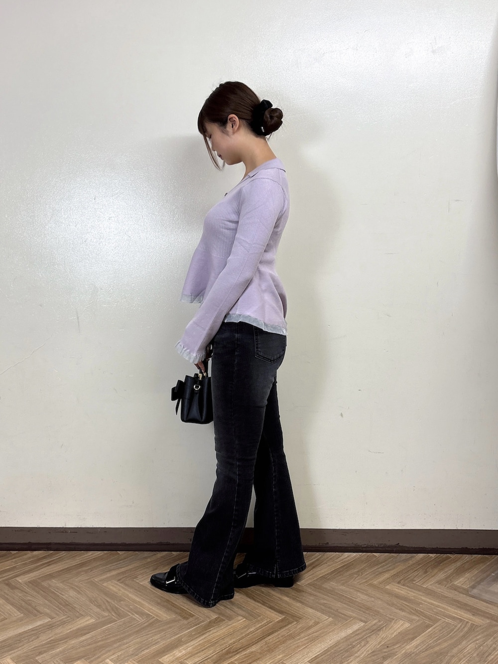 ブラック系のデニムパンツ、パープル系のニット/セーターを着用したレディースの秋コーディネートの3枚目の写真