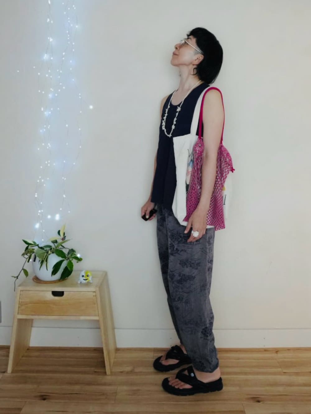 ブルー系のタンクトップ、ブルー系のパンツ、ピンク系のエコバッグ/サブバッグを着用したメンズの夏コーディネートの3枚目の写真