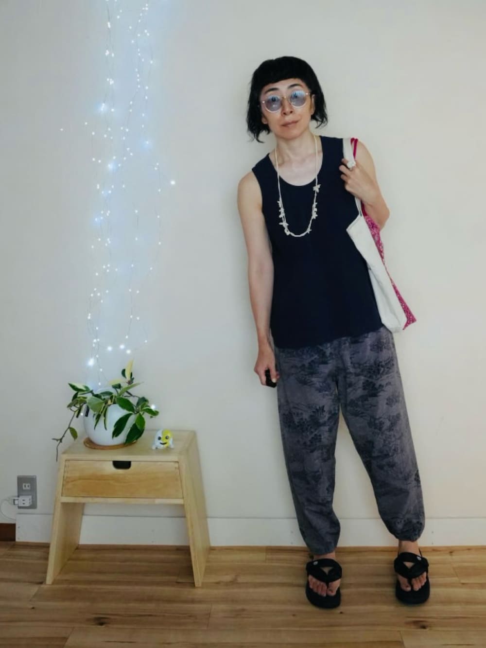 ブルー系のタンクトップ、ブルー系のパンツ、ピンク系のエコバッグ/サブバッグを着用したメンズの夏コーディネートの2枚目の写真