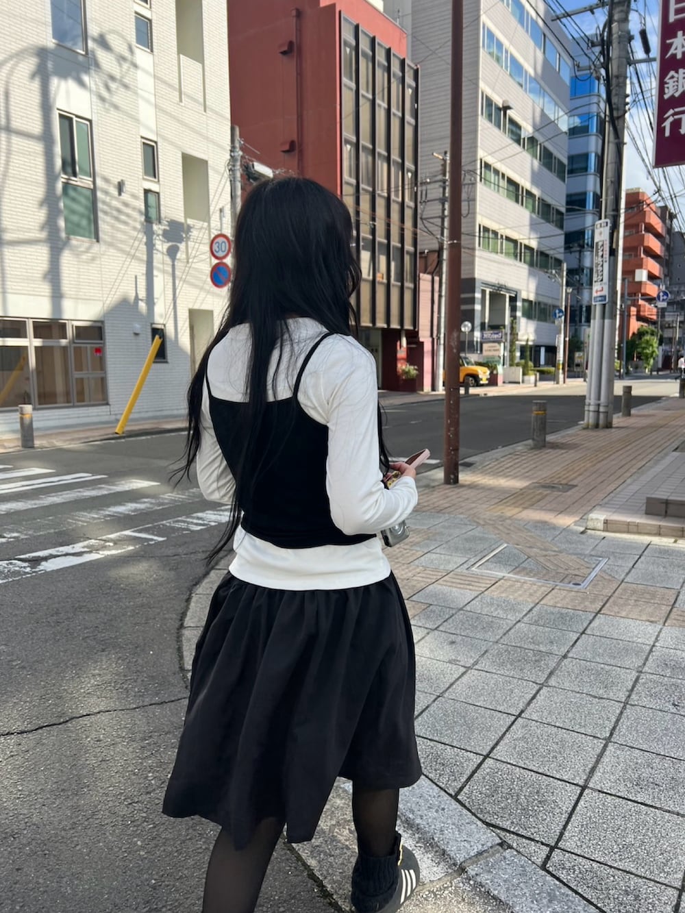 ホワイト系のTシャツ/カットソー、ブラック系のスカート、ブラック系のレッグウォーマーを着用したレディースの冬コーディネートの2枚目の写真