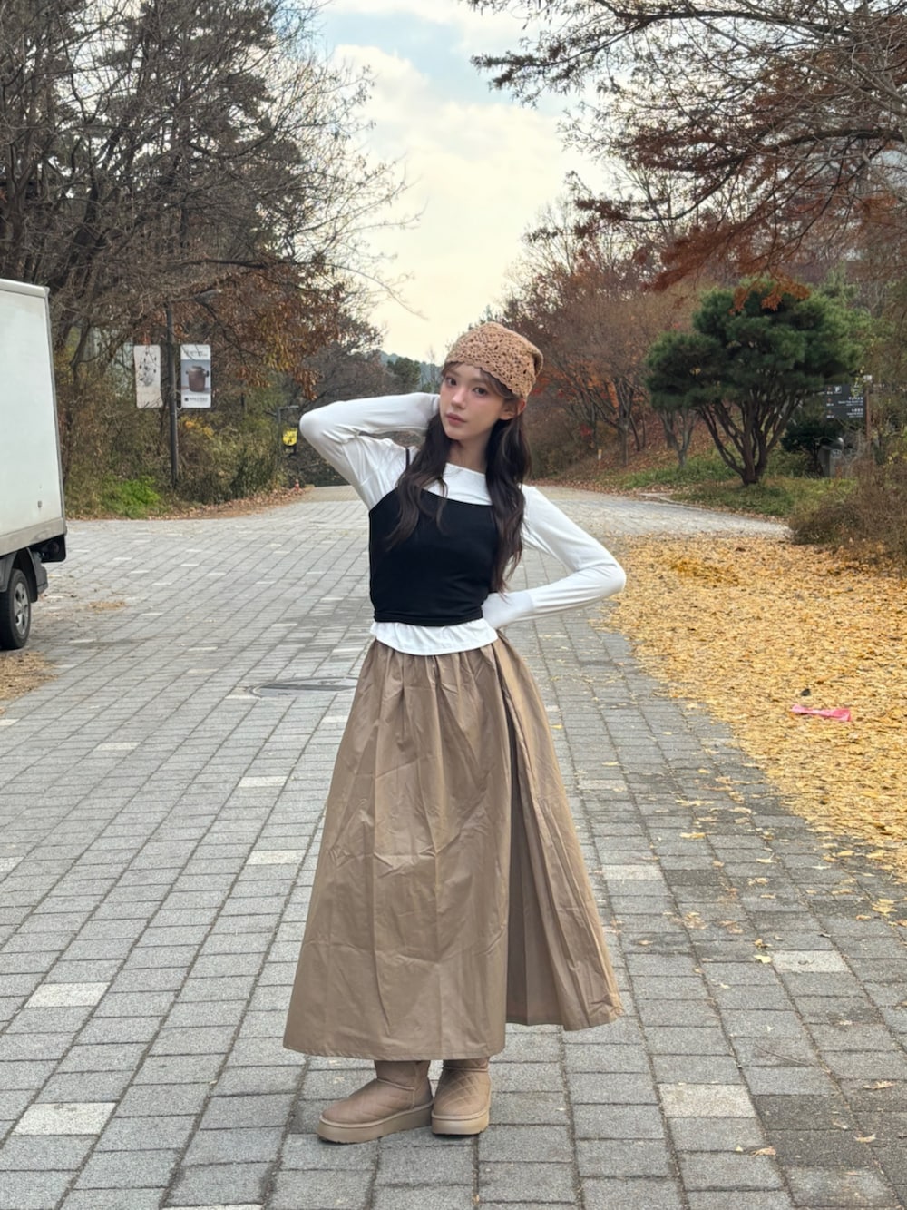 ブラウン系のブーツ、ホワイト系のTシャツ/カットソー、ベージュ系のニットキャップ/ビーニーを着用したレディースの冬コーディネートの3枚目の写真