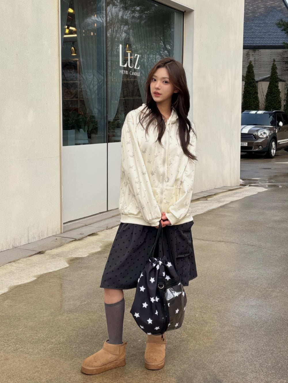 ブルー系のカーディガン/ボレロ、ブラック系のバックパック/リュックを着用したレディースの冬コーディネートの2枚目の写真