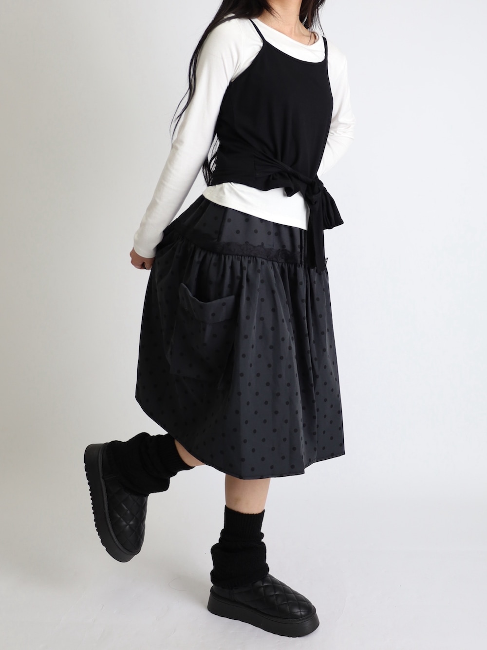 ブラック系のブーツ、ホワイト系のTシャツ/カットソー、ブラック系のレッグウォーマーを着用したレディースの秋コーディネートの2枚目の写真