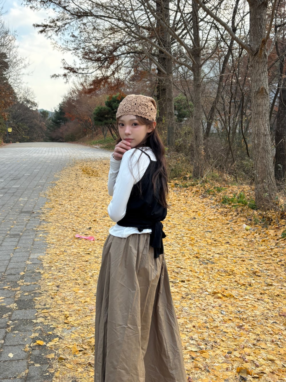 ブラウン系のブーツ、ホワイト系のTシャツ/カットソー、ベージュ系のニットキャップ/ビーニーを着用したレディースの冬コーディネートの4枚目の写真