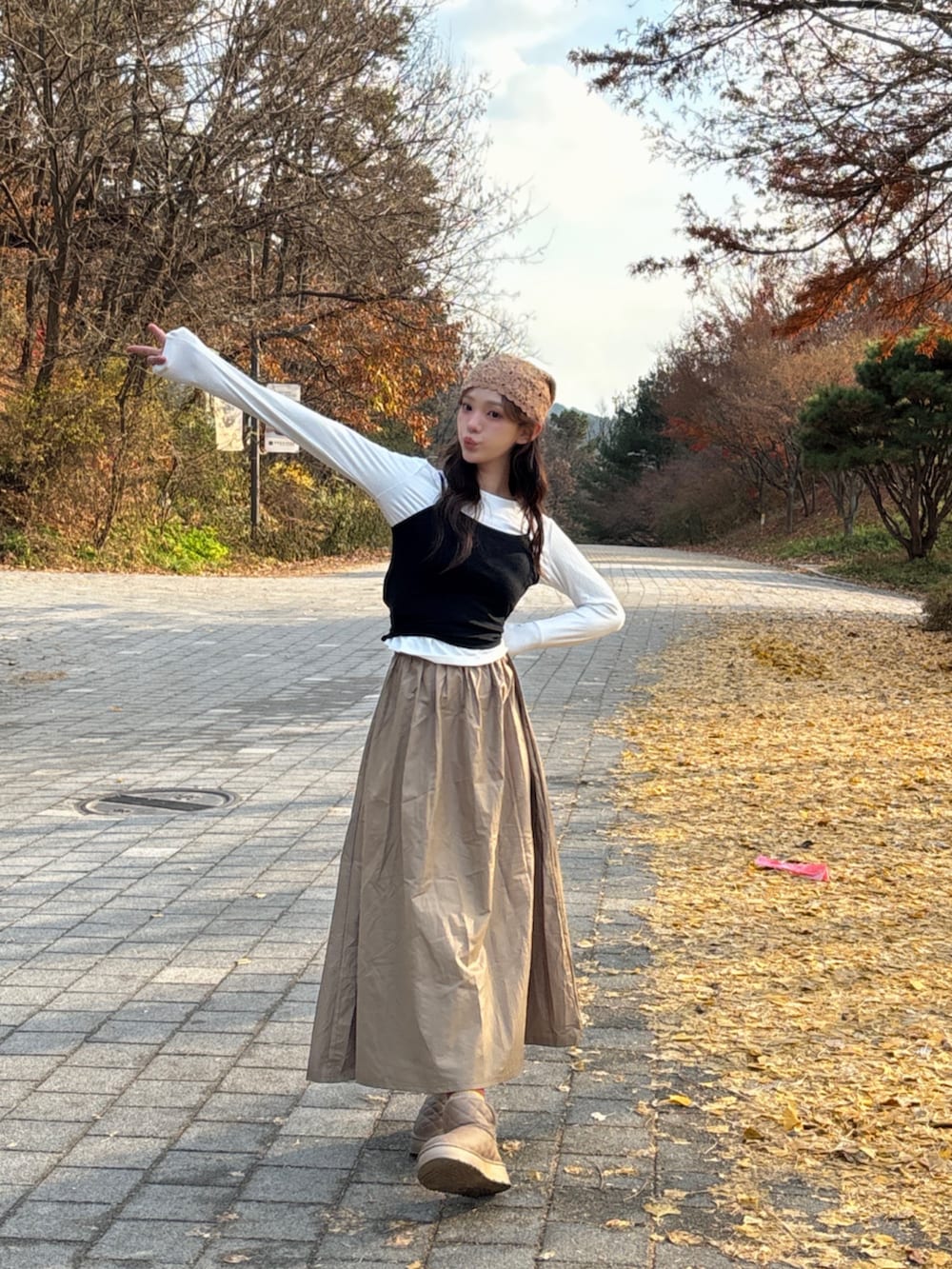 ブラウン系のブーツ、ホワイト系のTシャツ/カットソー、ベージュ系のニットキャップ/ビーニーを着用したレディースの冬コーディネートの7枚目の写真