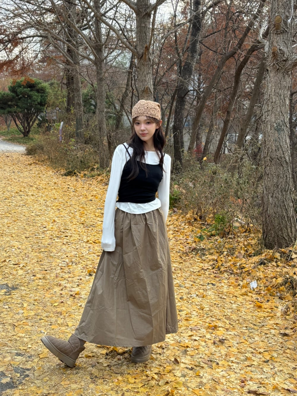 ブラウン系のブーツ、ホワイト系のTシャツ/カットソー、ベージュ系のニットキャップ/ビーニーを着用したレディースの冬コーディネートの6枚目の写真