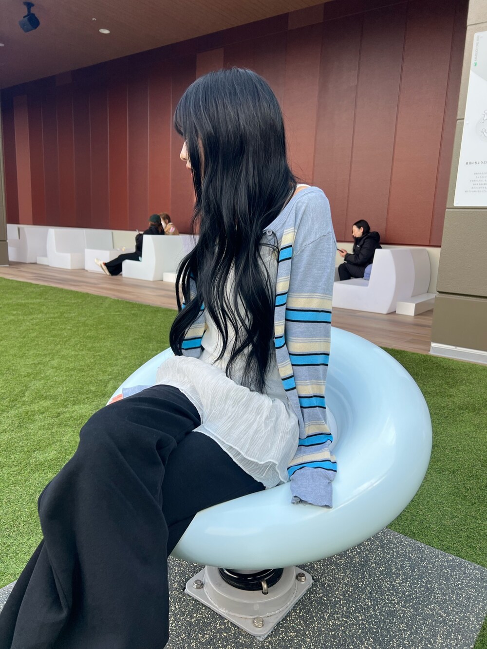 グレー系のTシャツ/カットソー、ブラック系のスウェットパンツ、ブラック系のブーツを着用したレディースの冬コーディネートの3枚目の写真