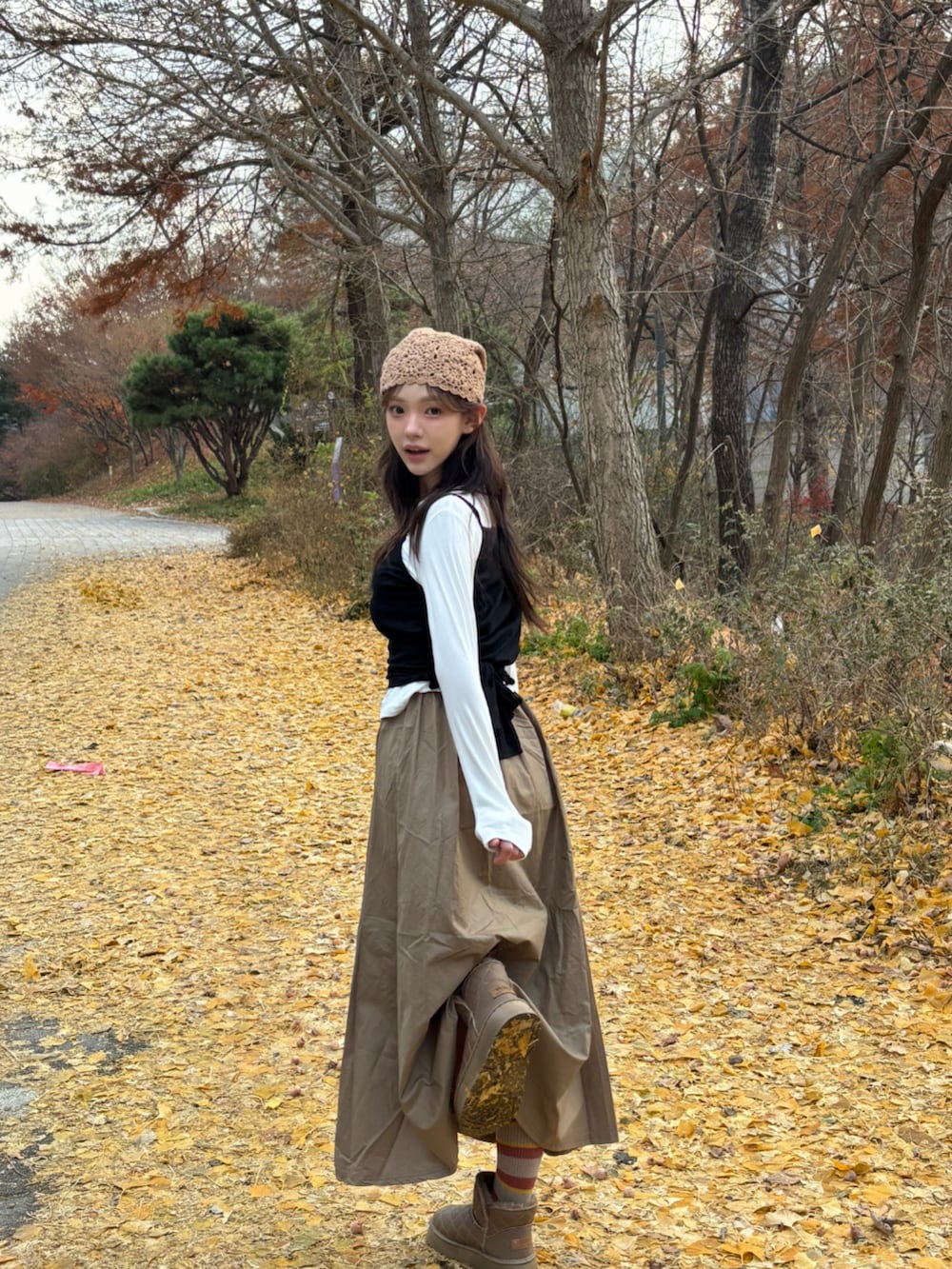 ブラウン系のブーツ、ホワイト系のTシャツ/カットソー、ベージュ系のニットキャップ/ビーニーを着用したレディースの冬コーディネートの5枚目の写真