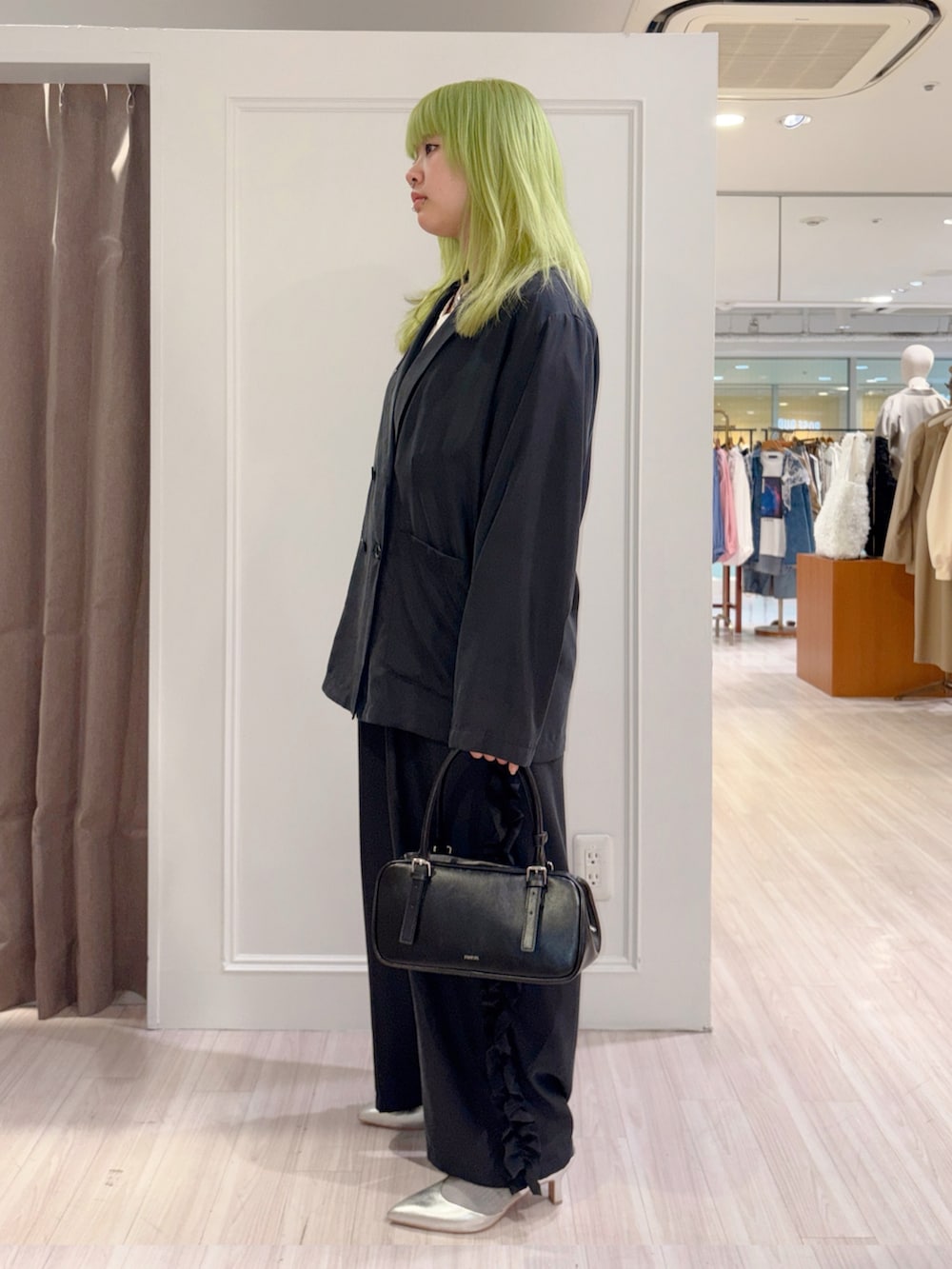 ブラック系のその他アウター、ブラック系のその他パンツ、ホワイト系のシャツ/ブラウスを着用したレディースの春コーディネートの2枚目の写真