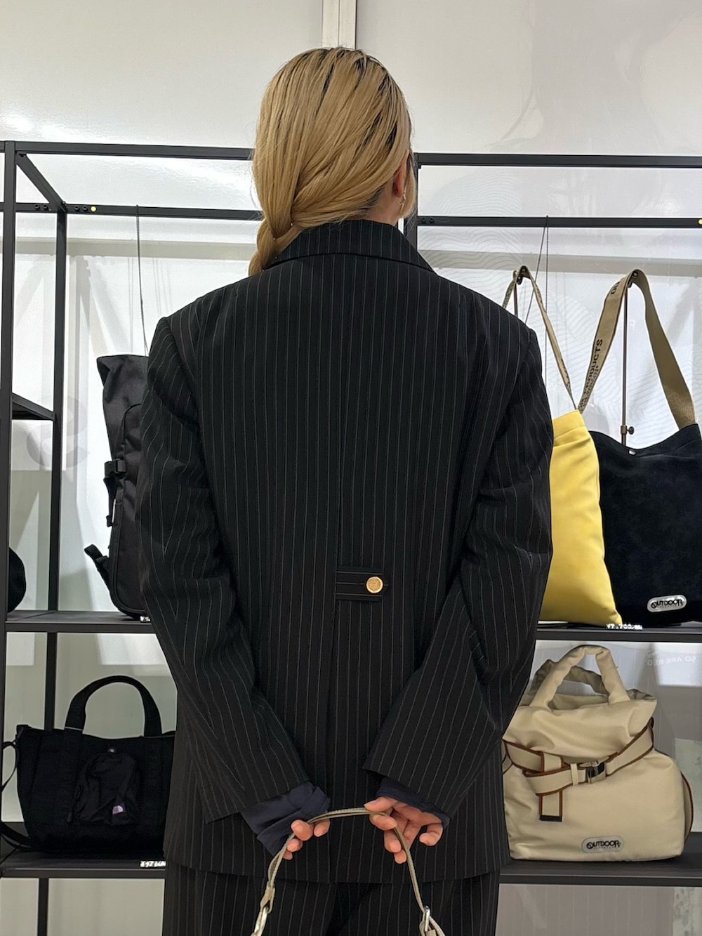 ブラック系のテーラードジャケット、ブラック系のその他パンツ、ブルー系のTシャツ/カットソーを着用したレディースの春コーディネートの5枚目の写真