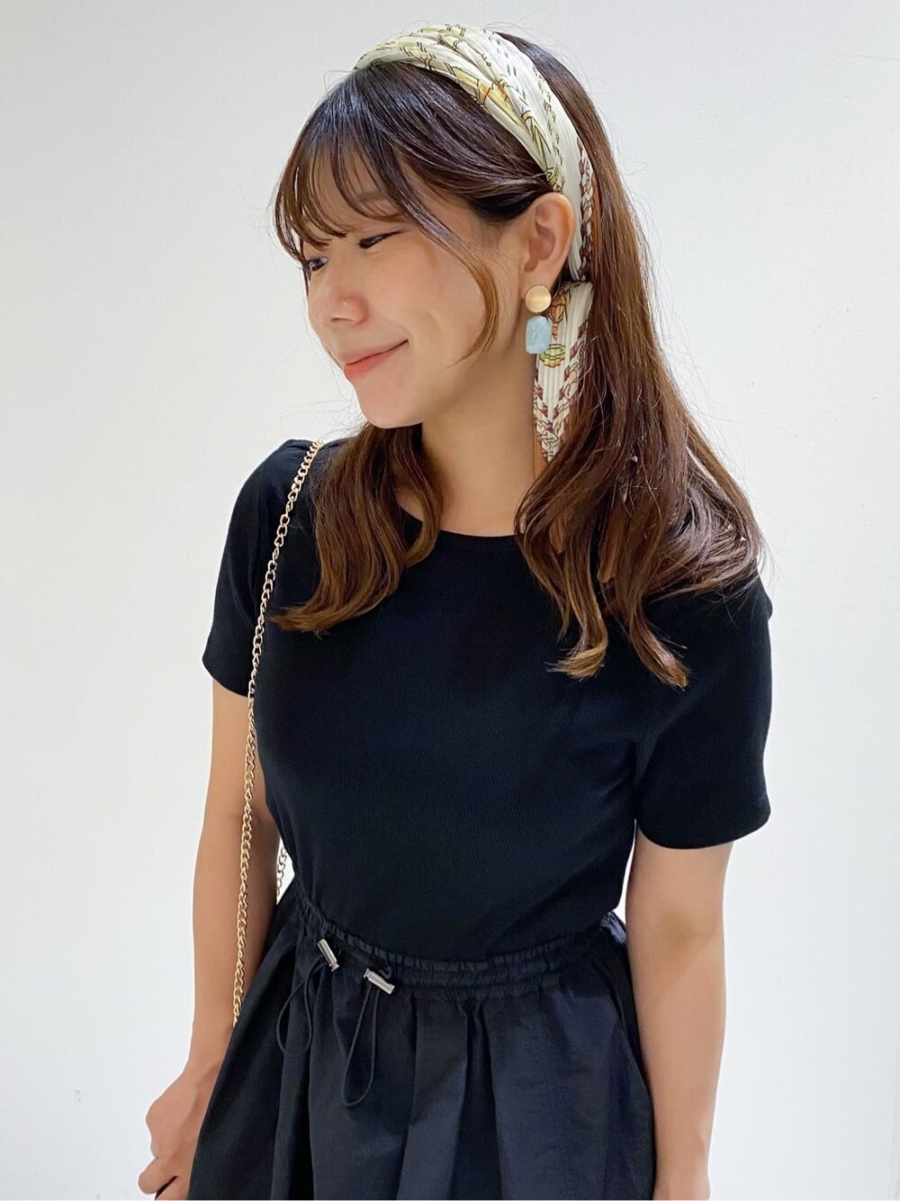 ブラック系のワンピース、イエロー系のパンプス、ブラウン系のバンダナ/スカーフを着用したレディースの夏コーディネートの8枚目の写真
