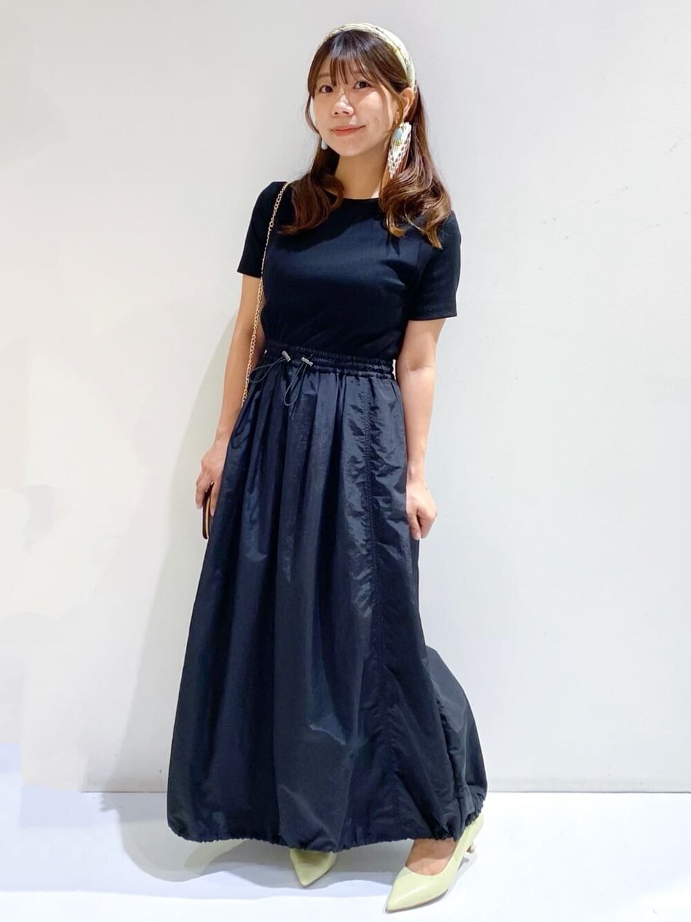 ブラック系のワンピース、イエロー系のパンプス、ブラウン系のバンダナ/スカーフを着用したレディースの夏コーディネートの3枚目の写真