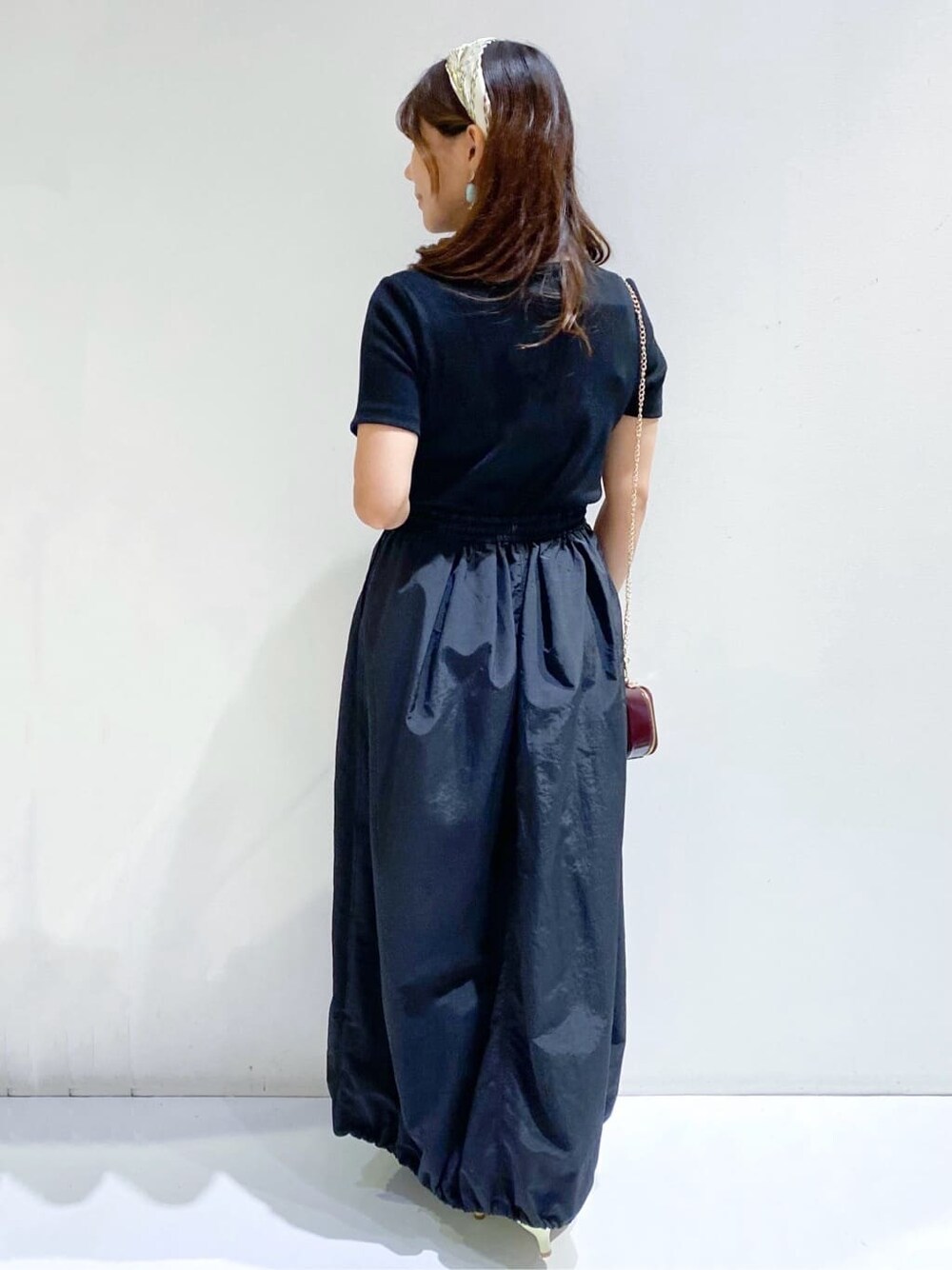 ブラック系のワンピース、イエロー系のパンプス、ブラウン系のバンダナ/スカーフを着用したレディースの夏コーディネートの6枚目の写真