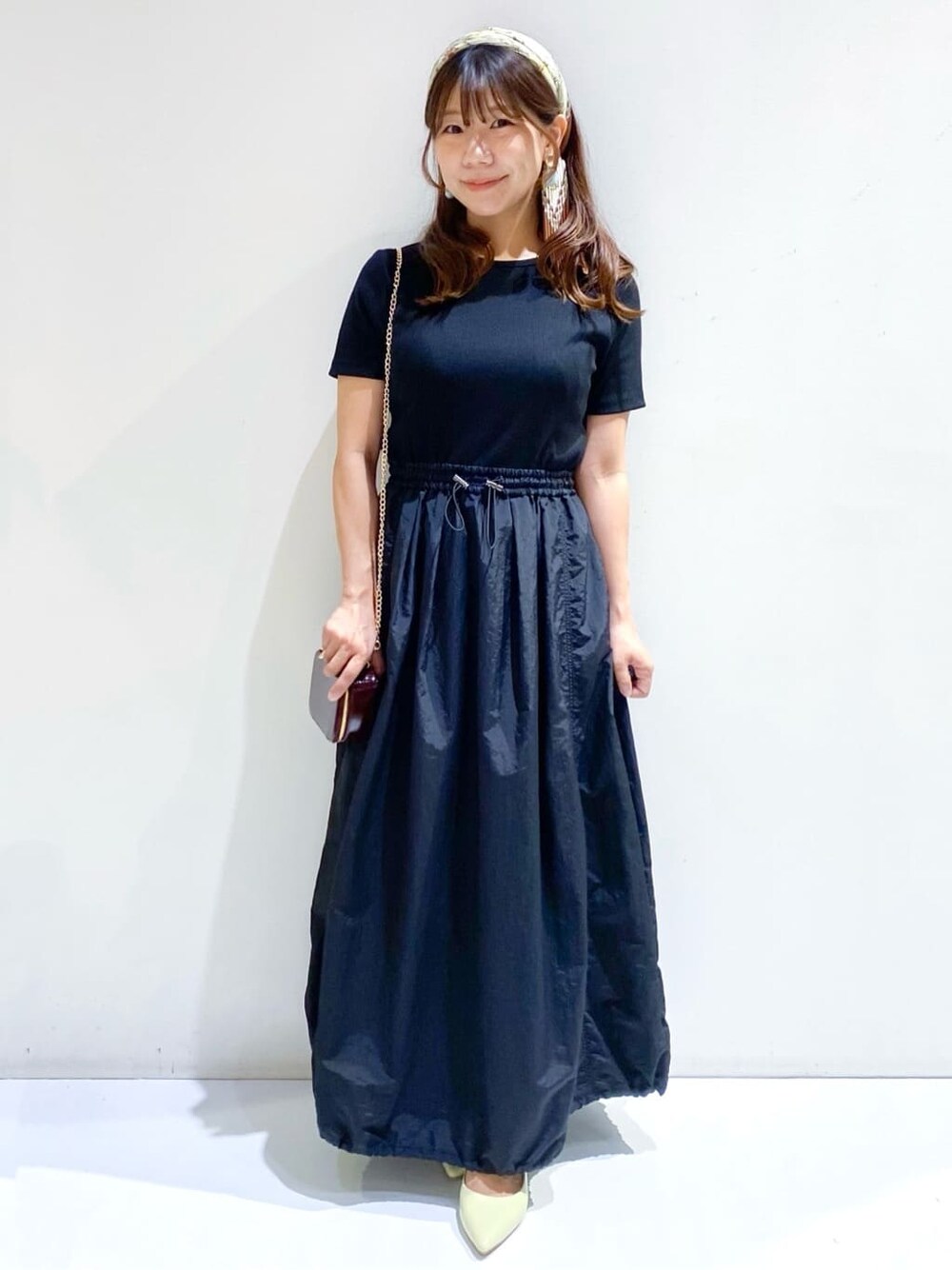 ブラック系のワンピース、イエロー系のパンプス、ブラウン系のバンダナ/スカーフを着用したレディースの夏コーディネートの2枚目の写真