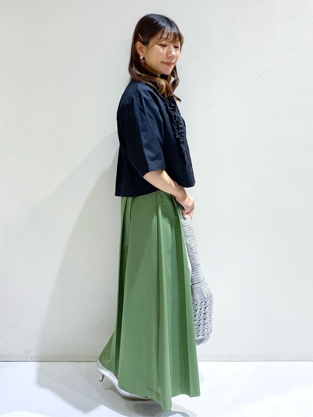 ブラック系のシャツ/ブラウス、ホワイト系のTシャツ/カットソー、グリーン系のスカートを着用したレディースの春コーディネートの3枚目の写真
