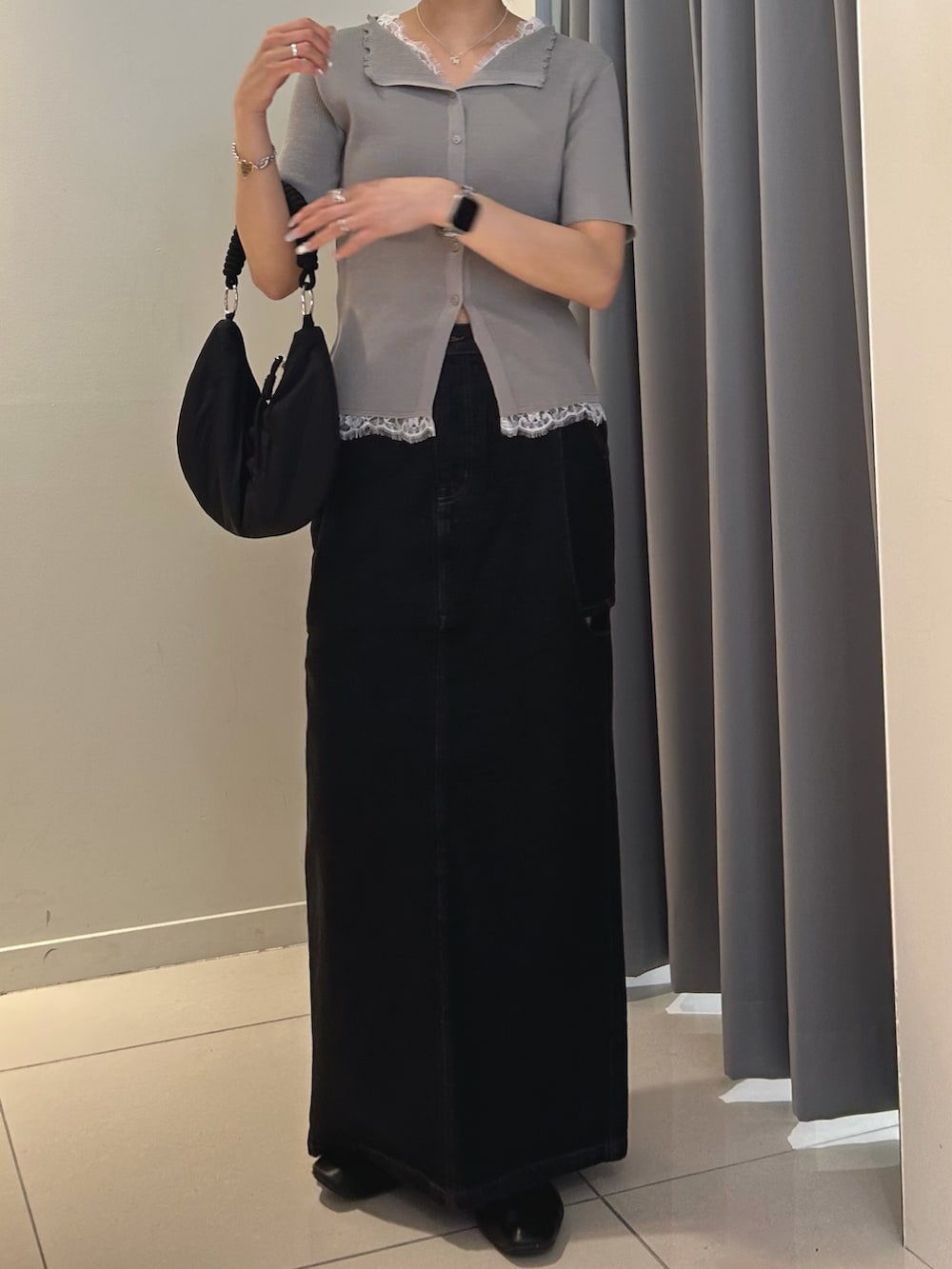 グレー系のニット/セーター、ブラック系のハンドバッグ、ブラック系のスカートを着用したレディースの夏コーディネートの2枚目の写真
