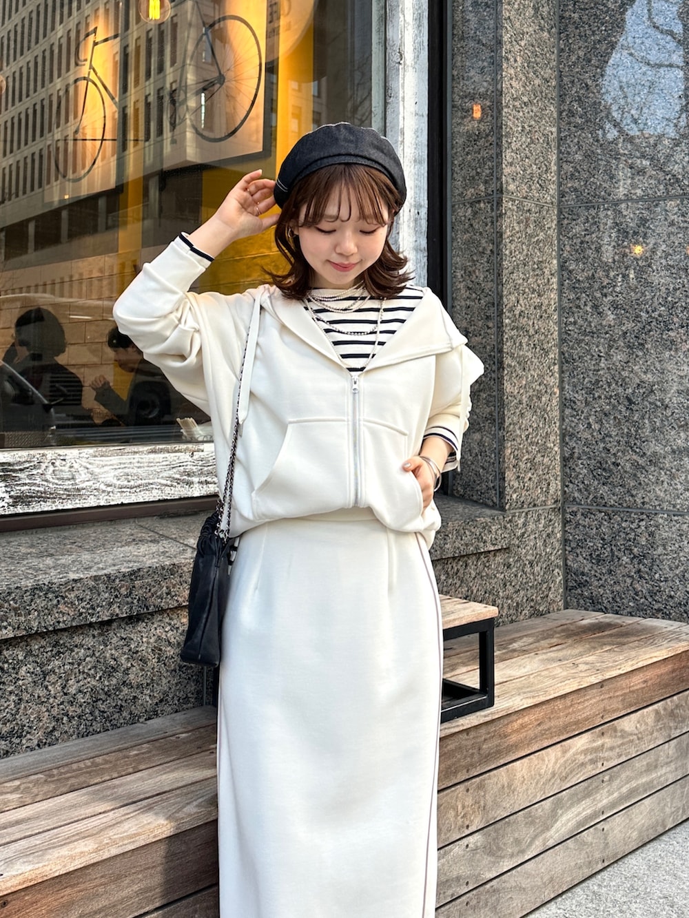 ホワイト系のスカート、ホワイト系のパーカーを着用したレディースの冬コーディネートの2枚目の写真