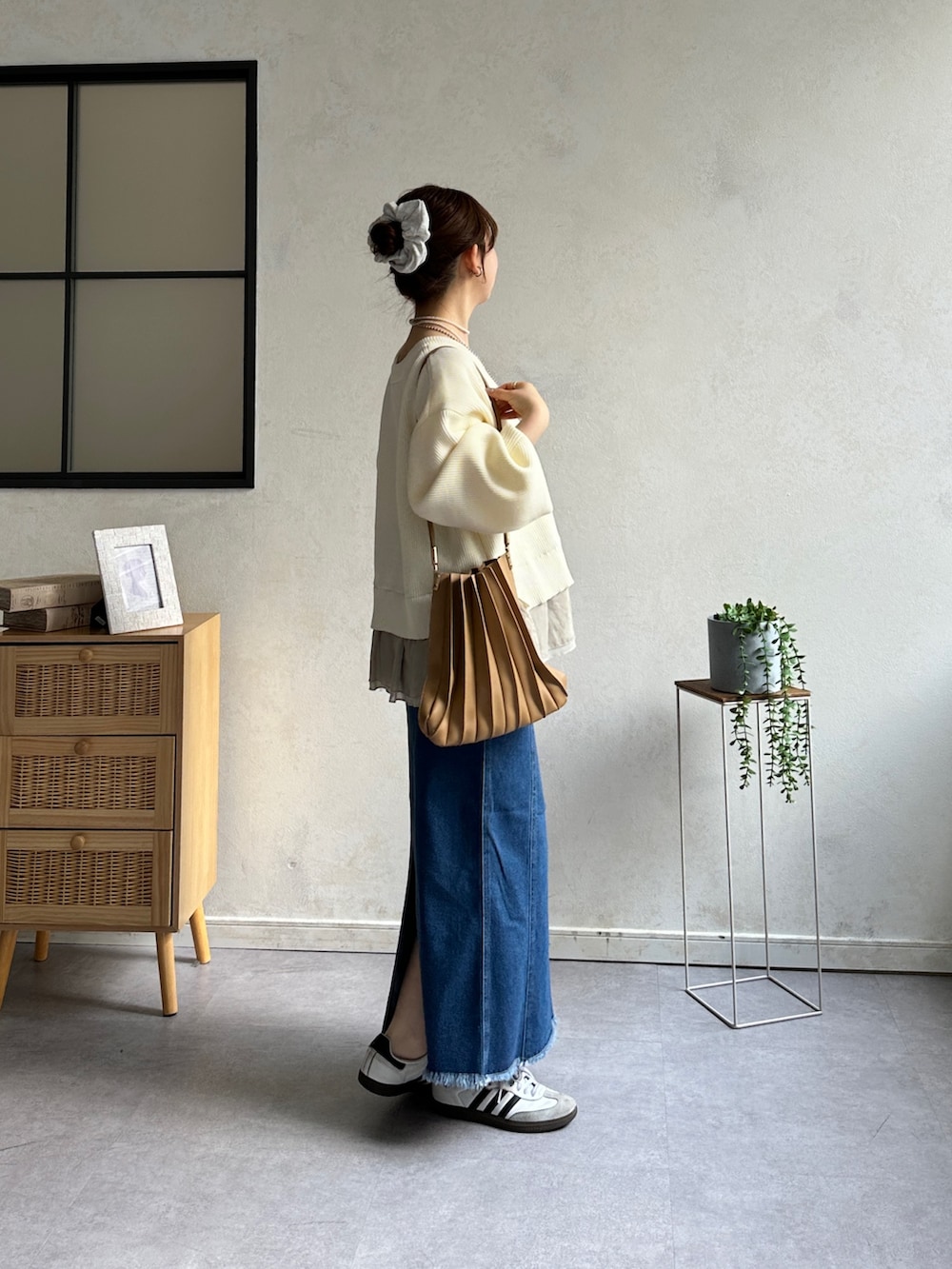 ホワイト系のニット/セーター、ブルー系のスカート、ホワイト系のスニーカーを着用したレディースの冬コーディネートの2枚目の写真