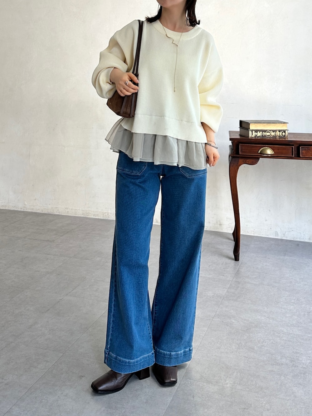 ブルー系のその他パンツ、ホワイト系のニット/セーター、ブラウン系のブーツを着用したレディースの冬コーディネートの3枚目の写真