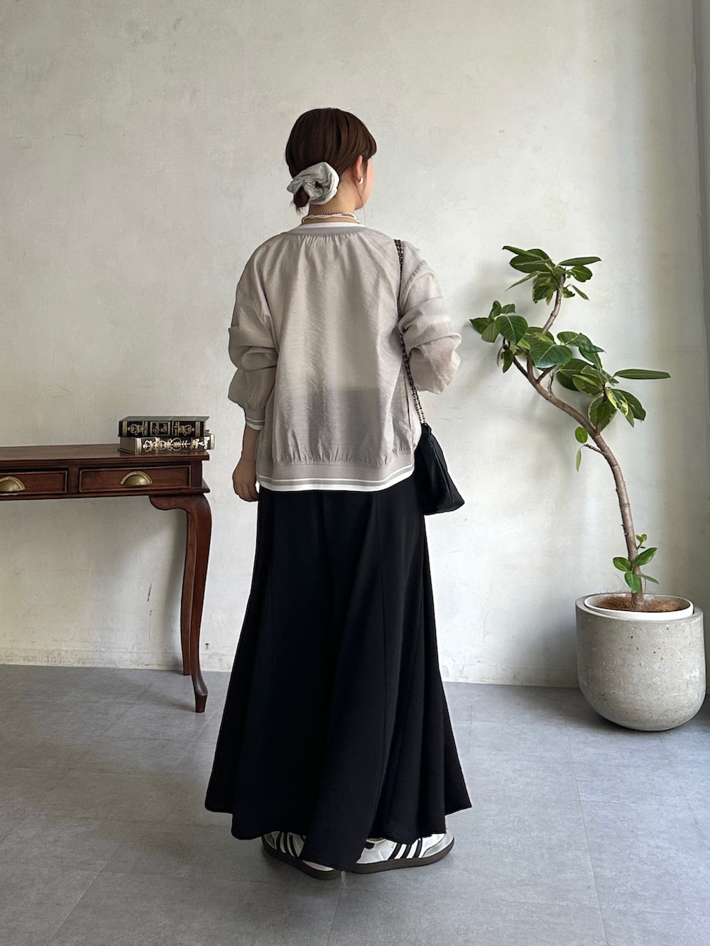 ブラック系のその他パンツ、グレー系のブルゾン、ホワイト系のスニーカーを着用したレディースの春コーディネートの2枚目の写真
