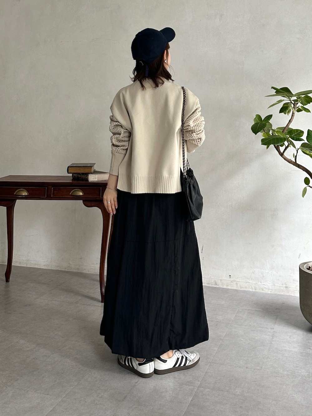 ブラック系のスカート、グレー系のTシャツ/カットソー、ベージュ系のカーディガン/ボレロを着用したレディースの春コーディネートの3枚目の写真