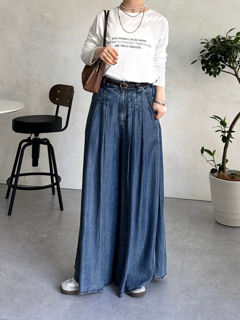 ブルー系のその他パンツ、ホワイト系のTシャツ/カットソー、ホワイト系のスニーカーを着用したレディースの冬コーディネートの4枚目の写真