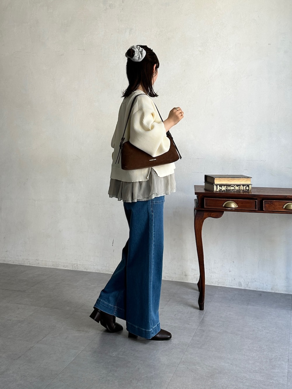 ブルー系のその他パンツ、ホワイト系のニット/セーター、ブラウン系のブーツを着用したレディースの冬コーディネートの2枚目の写真