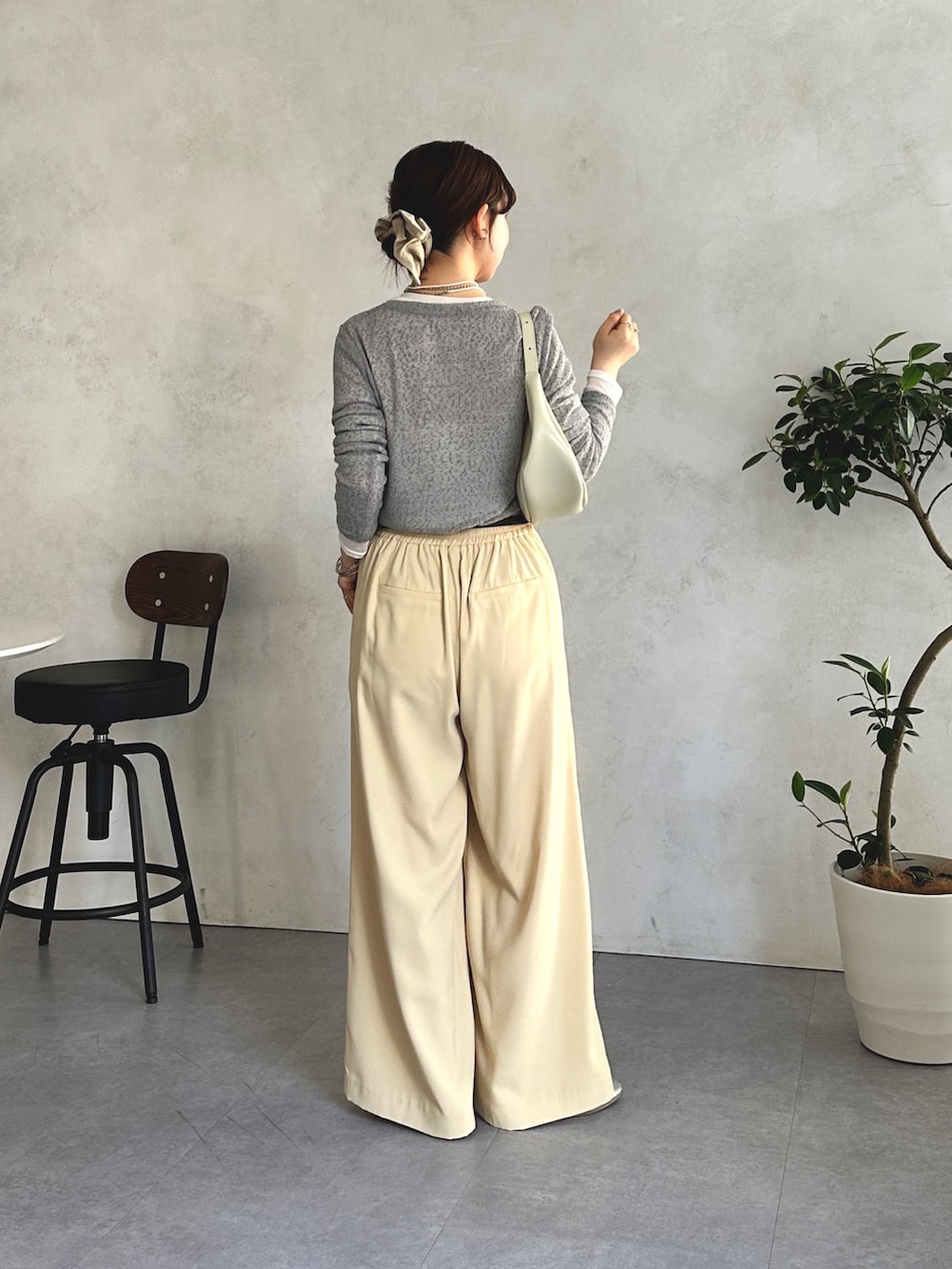 イエロー系のワンピース、グレー系のTシャツ/カットソーを着用したレディースの春コーディネートの2枚目の写真