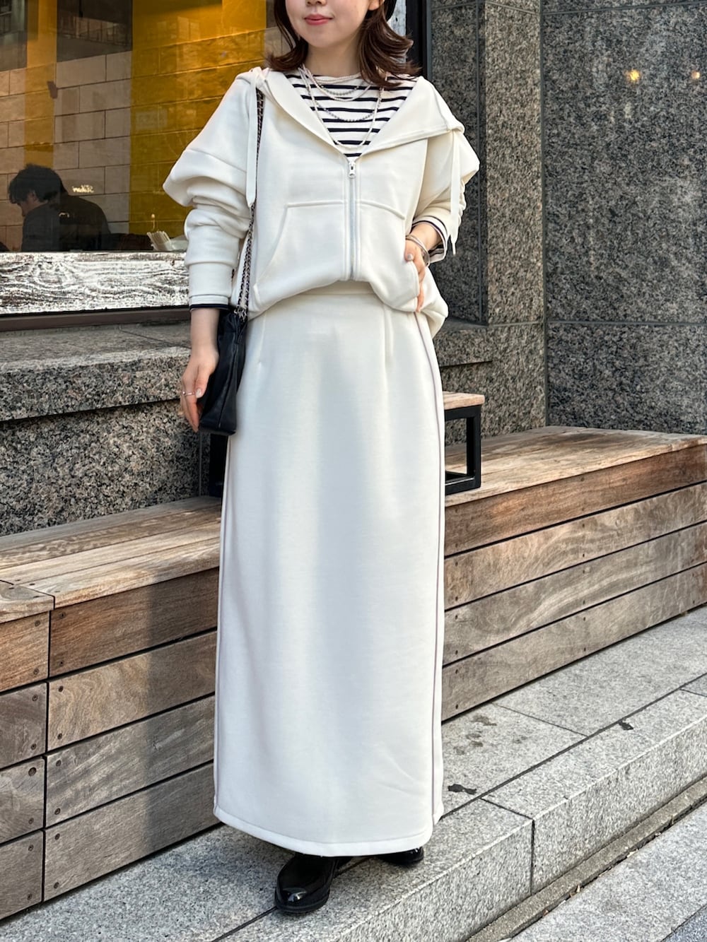 ホワイト系のスカート、ホワイト系のパーカーを着用したレディースの冬コーディネートの3枚目の写真