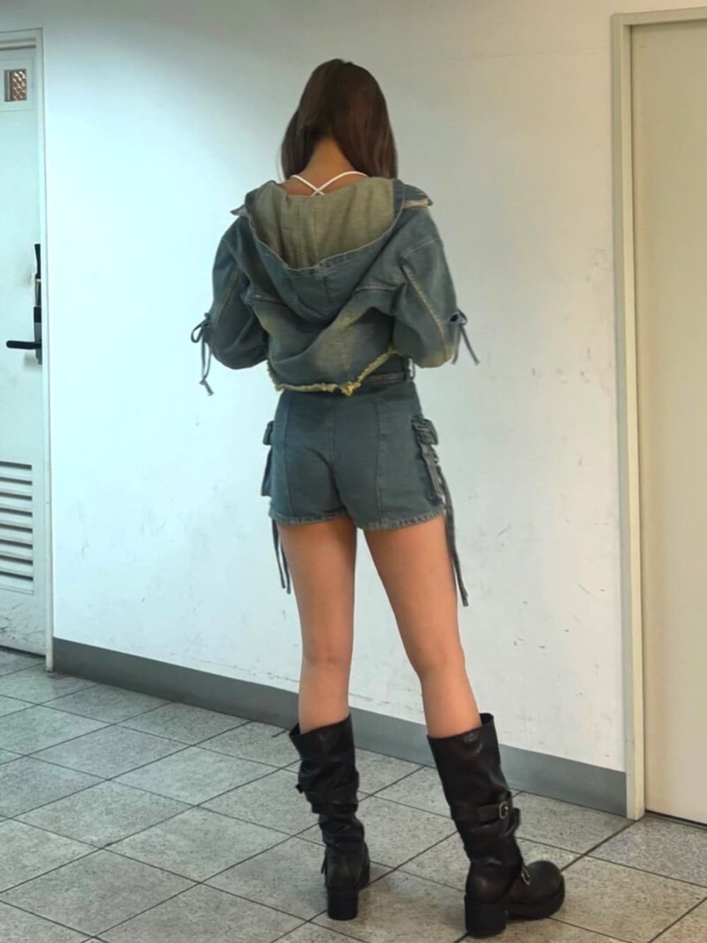 ブラック系のブーツ、ブルー系のデニムジャケット、ホワイト系のTシャツ/カットソーを着用したレディースの冬コーディネートの3枚目の写真