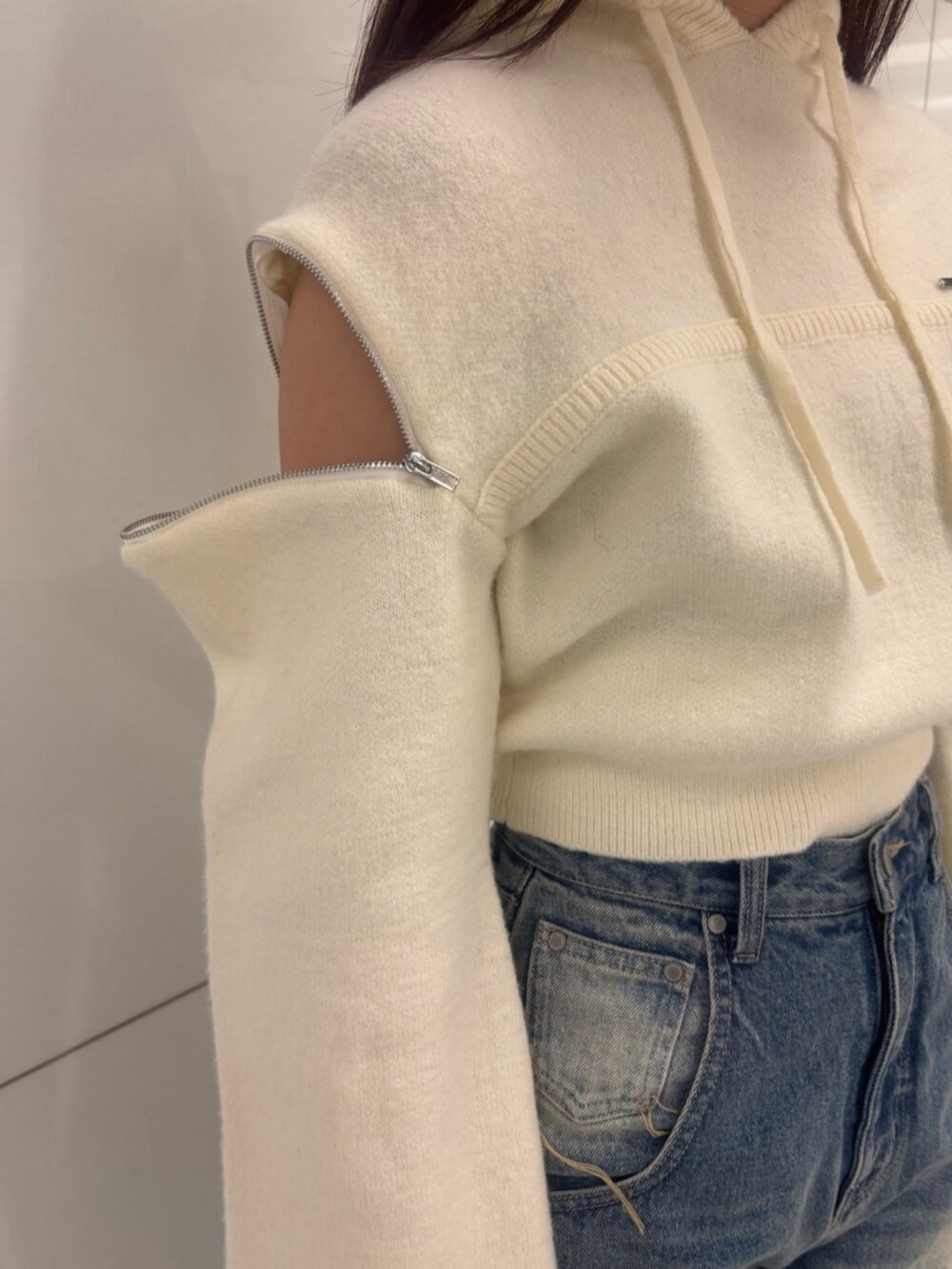 ブラック系のブーツ、ホワイト系のパーカー、ブルー系のデニムパンツを着用したレディースの冬コーディネートの6枚目の写真