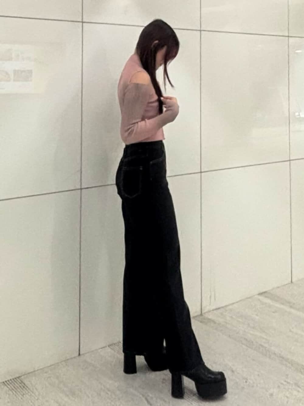 ブラック系のブーツ、ピンク系のニット/セーター、ブルー系のデニムパンツを着用したレディースの冬コーディネートの2枚目の写真