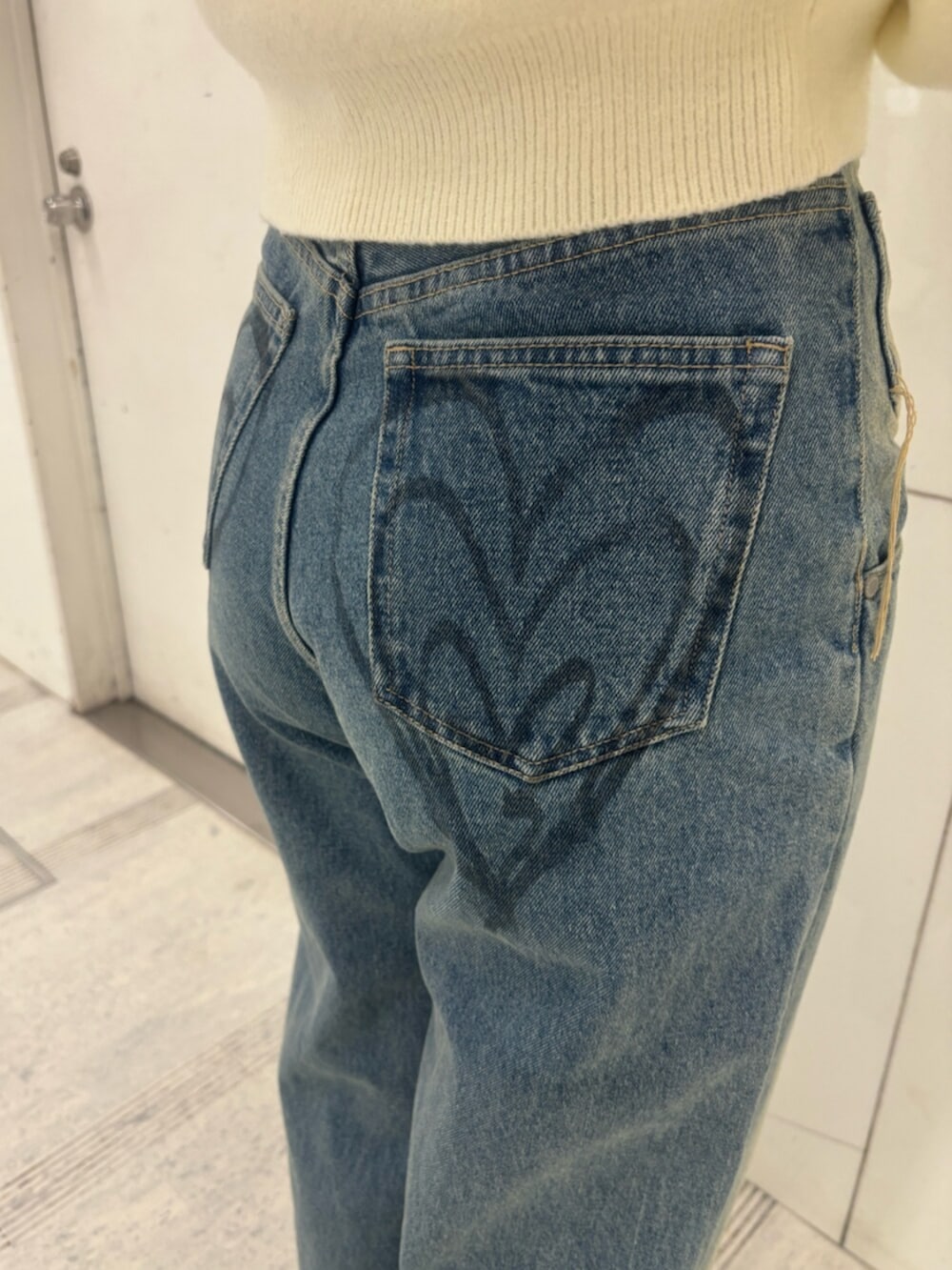 ブラック系のブーツ、ホワイト系のパーカー、ブルー系のデニムパンツを着用したレディースの冬コーディネートの9枚目の写真