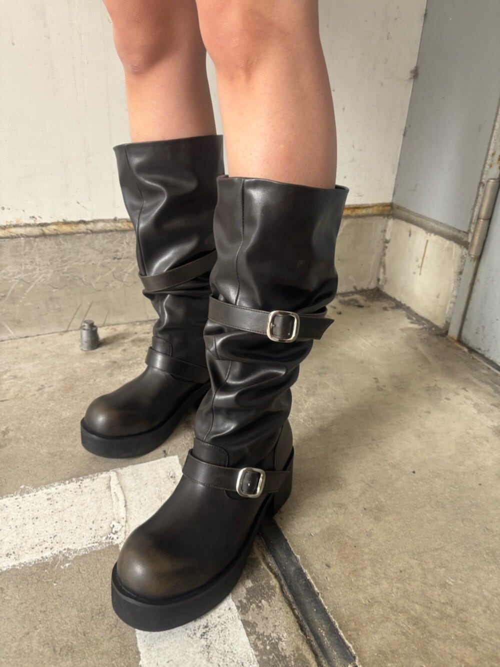 ブラック系のブーツ、ブラック系のスカート、ホワイト系のTシャツ/カットソーを着用したレディースの春コーディネートの6枚目の写真