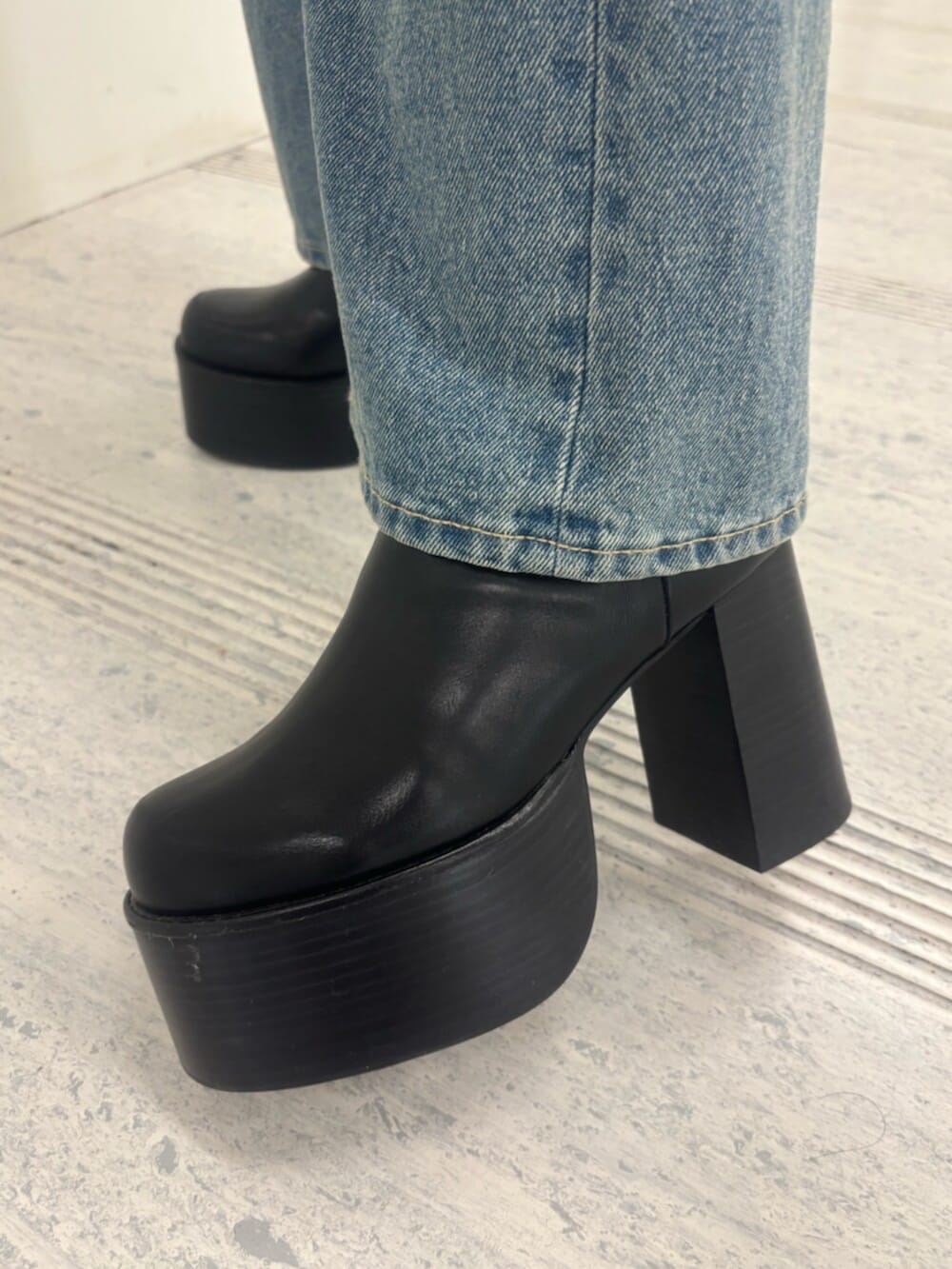 ブラック系のブーツ、ホワイト系のパーカー、ブルー系のデニムパンツを着用したレディースの冬コーディネートの10枚目の写真