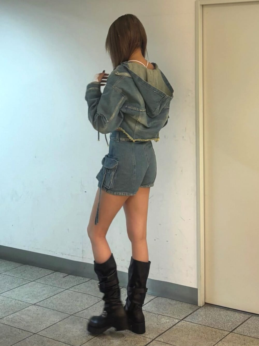 ブラック系のブーツ、ブルー系のデニムジャケット、ホワイト系のTシャツ/カットソーを着用したレディースの冬コーディネートの2枚目の写真