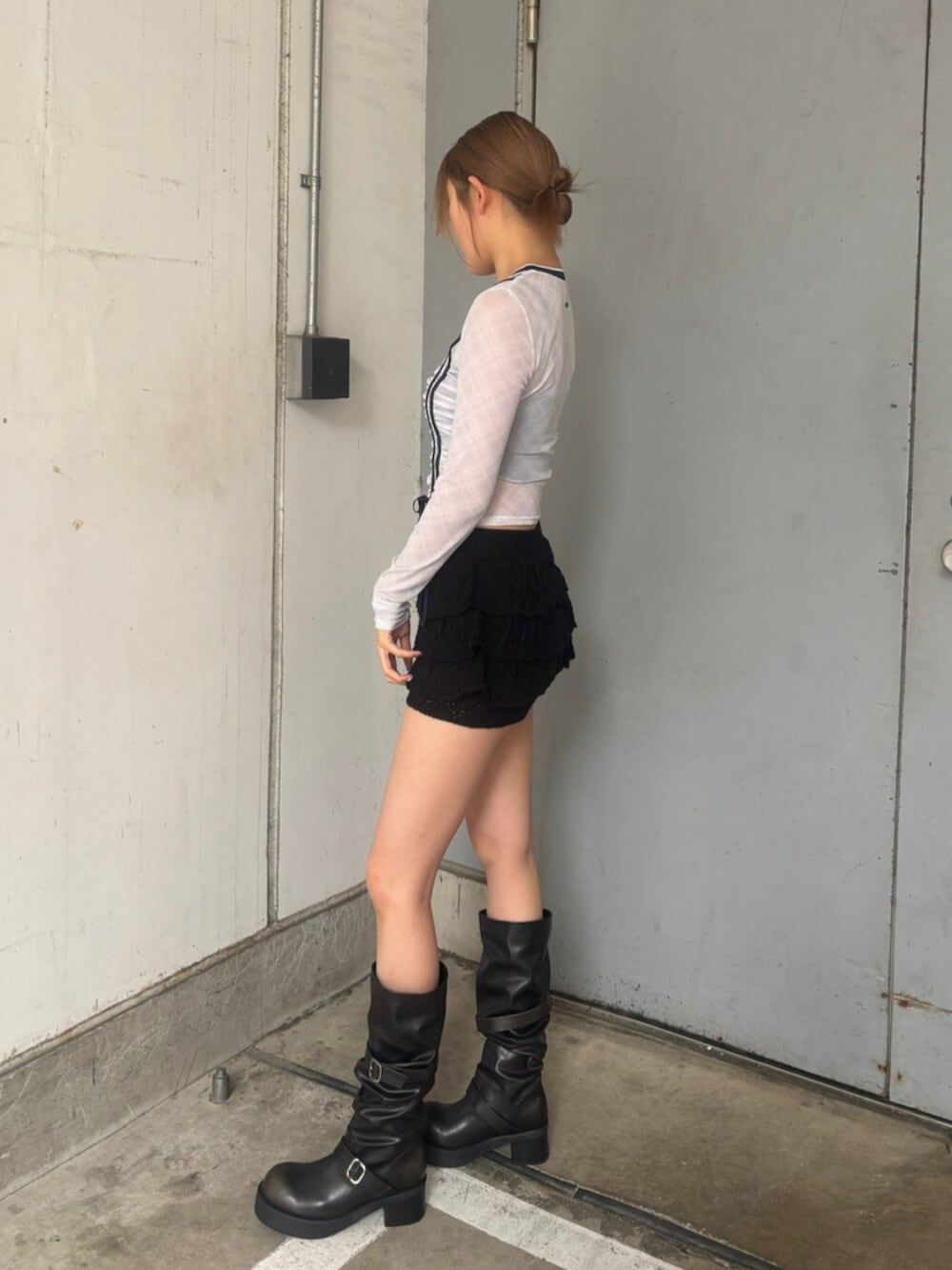 ブラック系のブーツ、ブラック系のスカート、ホワイト系のTシャツ/カットソーを着用したレディースの春コーディネートの2枚目の写真