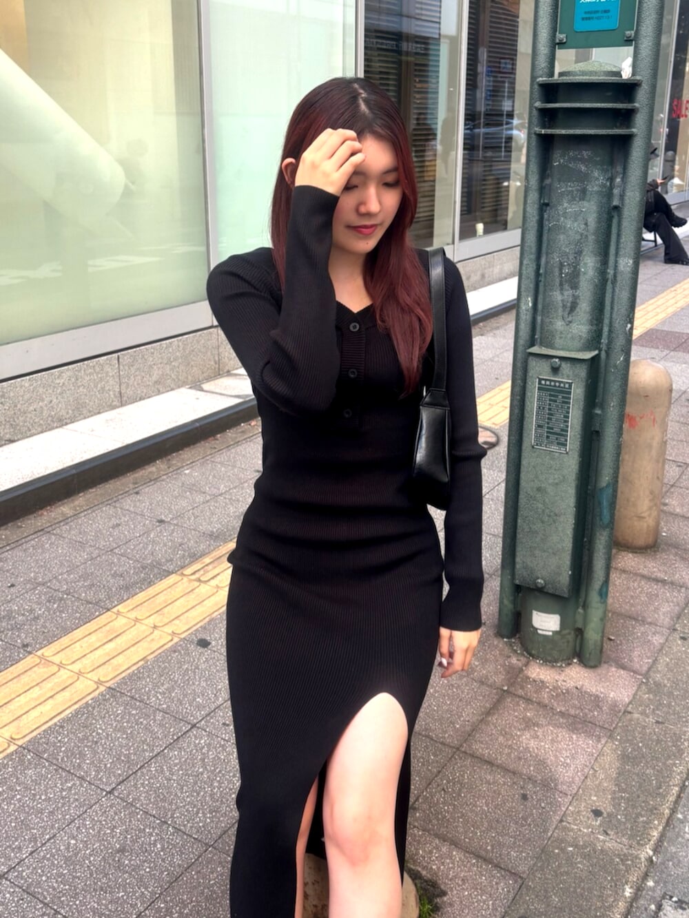 ブラック系のブーツ、ブラック系のワンピース、ブラック系のショルダーバッグを着用したレディースの冬コーディネートの4枚目の写真