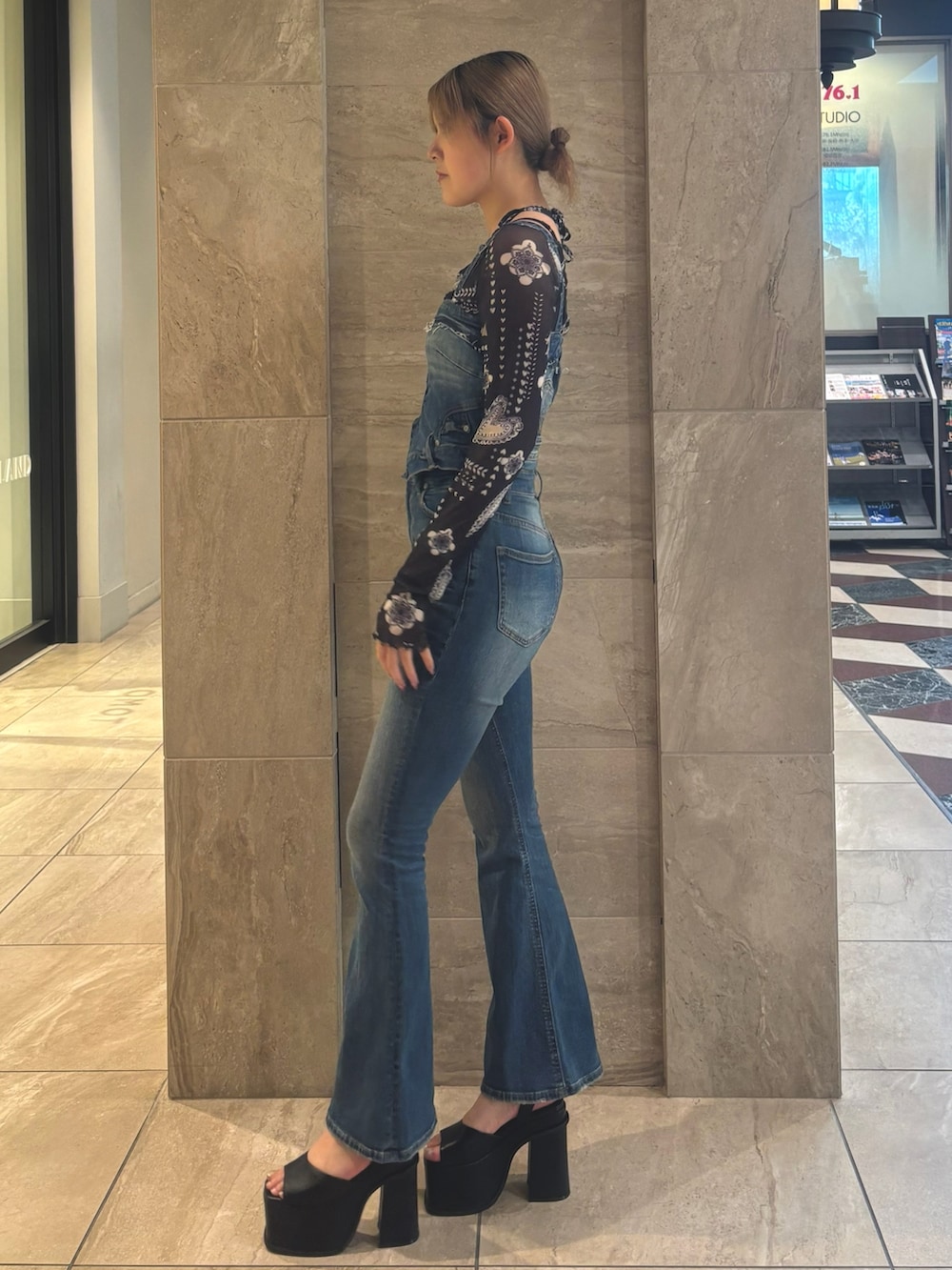 ブルー系のサロペット/オーバーオール、ブルー系のTシャツ/カットソー、ブラック系のサンダルを着用したレディースの春コーディネートの2枚目の写真