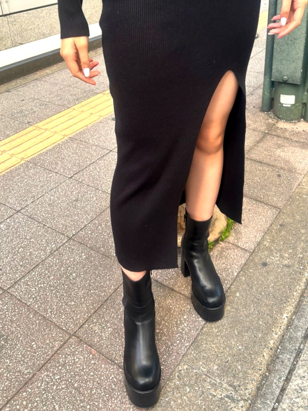 ブラック系のブーツ、ブラック系のワンピース、ブラック系のショルダーバッグを着用したレディースの冬コーディネートの6枚目の写真